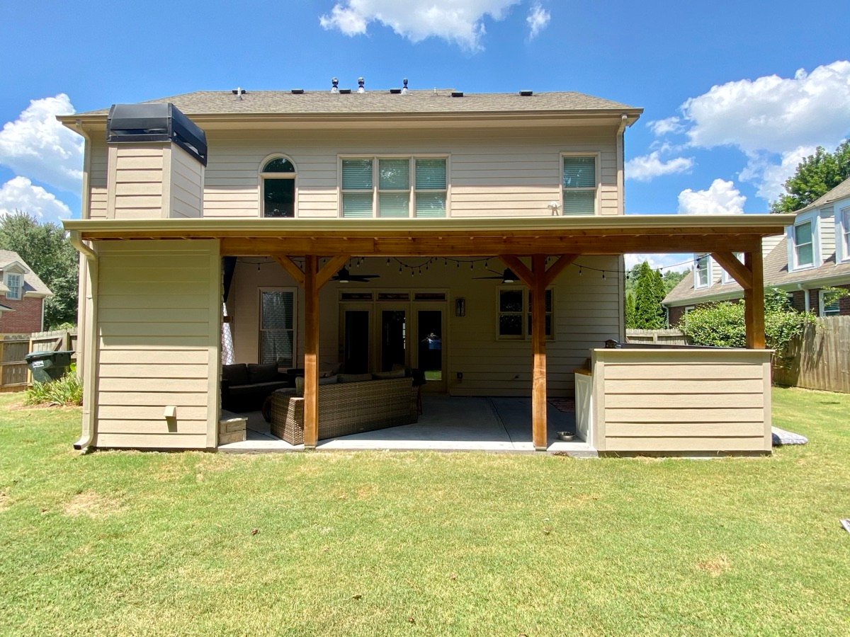 Custom home exterior with covered outdoor living space by GHIR Construction in Dawsonville, GA